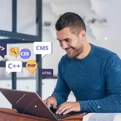 A Web Developer happy with his progress while working on a laptop